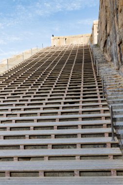 Persepolis UNESCO Dünya Mirasları Alanında İran 'ın Şiraz şehrinde bulutlu mavi gökyüzüne karşı levrek kabartması ile merdivenlerin arkasındaki Apadana ve Tachara Sarayı harabeleri. Orta Doğu, Asya