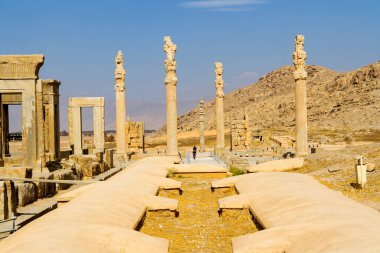 Persepolis UNESCO Dünya Mirasları Alanında İran 'ın Şiraz şehrinde bulutlu mavi gökyüzüne karşı levrek kabartması ile merdivenlerin arkasındaki Apadana ve Tachara Sarayı harabeleri. Orta Doğu, Asya