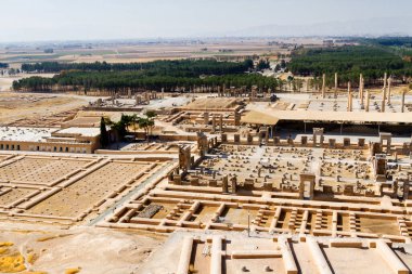 Persepolis UNESCO Dünya Mirasları Alanında İran 'ın Şiraz şehrinde bulutlu mavi gökyüzüne karşı levrek kabartması ile merdivenlerin arkasındaki Apadana ve Tachara Sarayı harabeleri. Orta Doğu, Asya