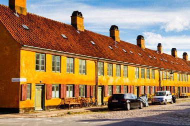 COPENHAGEN, DENMARK - 8 Ekim 2016: Nyboder 'in şirin sarı evleri, Kopenhag' ın ortaçağ bölgesi, Danimarka. Bisikletle binanın önüne park etmiş, kaldırıma park etmiş..