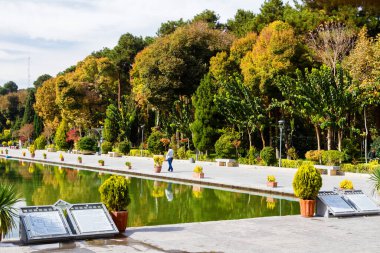 ISFAHAN, IRAN - 18 NOV 2016: Bahçedeki ağaçlarla çevrili antik Bagh-e Chehel Sotoun Sarayı önünde uzun bir havuz