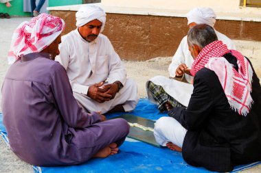 QESHM Adaları, İRAN - 23 Kasım 2016: İranlı erkekler yerde domino oynuyorlar.