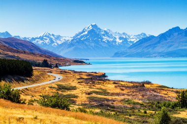 View of the majestic Aoraki Mount Cook with the road leading to Mount Cook Village. Taken during summer in New Zealand. clipart