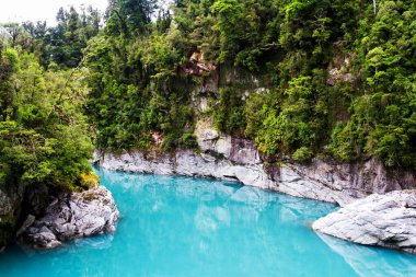 Hokitika Nehri 'nin mavi suları Hokitika Gorge Manzarası' ndaki kayanın yanında, batı kıyısında, Yeni Zelanda adasının güneyinde.