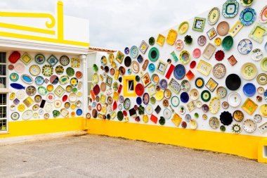 ALGARVE, PORTUGAL - 28 Nisan 2017: Duvar dekorasyon motifi olarak kullanılan vintage kil plakalar, çömlekler ve kaseler. Portekiz