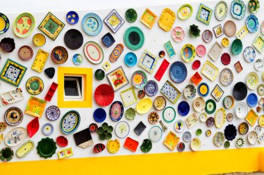 ALGARVE, PORTUGAL - 28 Nisan 2017: Duvar dekorasyon motifi olarak kullanılan vintage kil plakalar, çömlekler ve kaseler. Portekiz