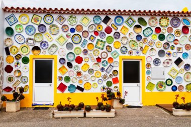 ALGARVE, PORTUGAL - 28 Nisan 2017: Duvar dekorasyon motifi olarak kullanılan vintage kil plakalar, çömlekler ve kaseler. Portekiz