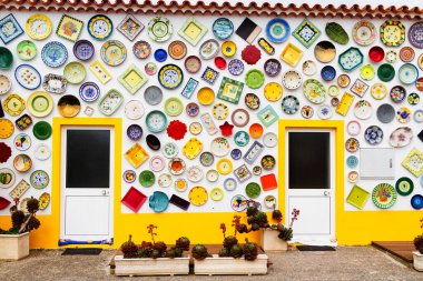 ALGARVE, PORTUGAL - 28 Nisan 2017: Duvar dekorasyon motifi olarak kullanılan vintage kil plakalar, çömlekler ve kaseler. Portekiz