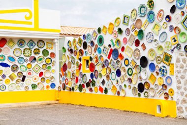 ALGARVE, PORTUGAL - 28 Nisan 2017: Duvar dekorasyon motifi olarak kullanılan vintage kil plakalar, çömlekler ve kaseler. Portekiz