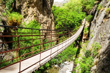 Los Cahorros, Granada, Endülüs, İspanya 'daki bir kanyon üzerinde geniş açılı bir köprü manzarası.
