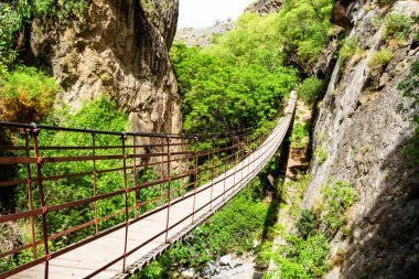 Los Cahorros, Granada, Endülüs, İspanya 'daki bir kanyon üzerinde geniş açılı bir köprü manzarası.