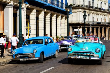 HAVANA, CUBA - 14 Kasım 2017: İnsanlar, eski arabalar ve renkli binaların olduğu tipik sokak sahnesi. 2 milyondan fazla nüfusuyla Havana, Küba 'nın başkenti ve Karayipler' in en büyük şehridir.