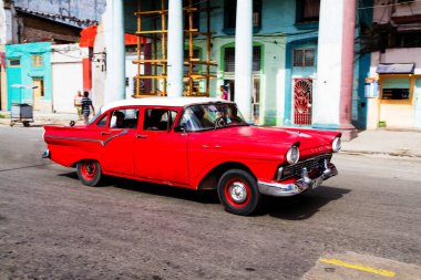 HAVANA, CUBA - 14 Kasım 2017: İnsanlar, eski arabalar ve renkli binaların olduğu tipik sokak sahnesi. 2 milyondan fazla nüfusuyla Havana, Küba 'nın başkenti ve Karayipler' in en büyük şehridir.