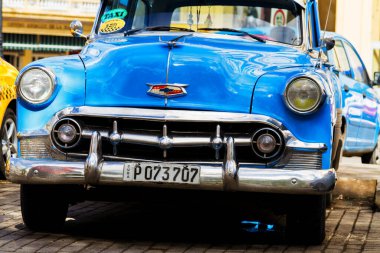 HAVANA, CUBA - 18 Kasım 2017: Havana, Küba sokaklarında eski renkli klasik araba. Ambargo nedeniyle Amerikan arabaları hala kullanılıyor ve turistler için taksi veya taşımacılık görevi görüyor.