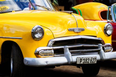 HAVANA, CUBA - 18 Kasım 2017: Havana, Küba sokaklarında eski renkli klasik araba. Ambargo nedeniyle Amerikan arabaları hala kullanılıyor ve turistler için taksi veya taşımacılık görevi görüyor.