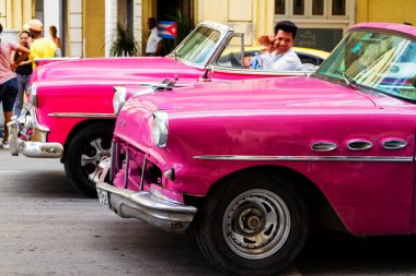 HAVANA, CUBA - 18 Kasım 2017: Havana, Küba sokaklarında eski renkli klasik araba. Ambargo nedeniyle Amerikan arabaları hala kullanılıyor ve turistler için taksi veya taşımacılık görevi görüyor.
