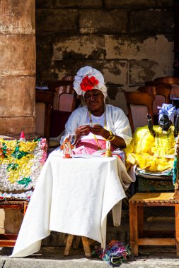 HAVANA, CUBA - 17 NOV 2017: Küba 'nın Havana kentinde büyük bir Küba purosu içerken geleneksel ve tipik kıyafetler giymiş Kübalı kadınlar fotoğraf için poz veriyorlar.