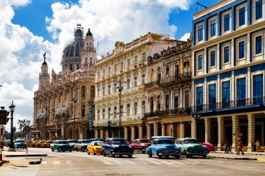 HAVANA, CUBA - 14 Kasım 2017: İnsanlar, eski arabalar ve renkli binaların olduğu tipik sokak sahnesi. 2 milyondan fazla nüfusuyla Havana, Küba 'nın başkenti ve Karayipler' in en büyük şehridir.