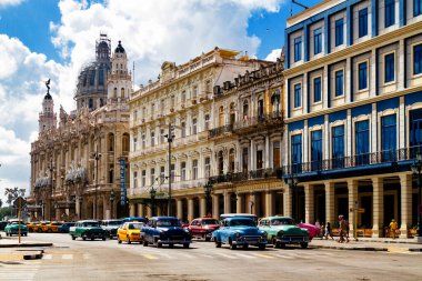HAVANA, CUBA - 14 Kasım 2017: İnsanlar, eski arabalar ve renkli binaların olduğu tipik sokak sahnesi. 2 milyondan fazla nüfusuyla Havana, Küba 'nın başkenti ve Karayipler' in en büyük şehridir.