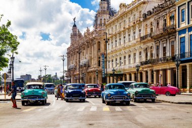 HAVANA, CUBA - 14 Kasım 2017: İnsanlar, eski arabalar ve renkli binaların olduğu tipik sokak sahnesi. 2 milyondan fazla nüfusuyla Havana, Küba 'nın başkenti ve Karayipler' in en büyük şehridir.