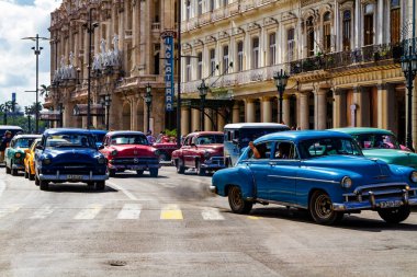 HAVANA, CUBA - 14 Kasım 2017: İnsanlar, eski arabalar ve renkli binaların olduğu tipik sokak sahnesi. 2 milyondan fazla nüfusuyla Havana, Küba 'nın başkenti ve Karayipler' in en büyük şehridir.