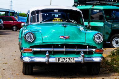 HAVANA, CUBA - 18 Kasım 2017: Havana, Küba sokaklarında eski renkli klasik araba. Ambargo nedeniyle Amerikan arabaları hala kullanılıyor ve turistler için taksi veya taşımacılık görevi görüyor.