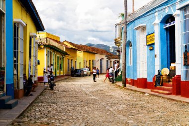 TRINIDAD, CUBA - 21 Kasım 2017: Renkli (kırmızı, sarı, yeşil, mavi) Trinidad caddesi manzaralı evler, kaldırımlı yollar ve pencerelerde parmaklıklar. Trinidad, UNESCO tarafından listelenmiş ve popüler bir şehir..
