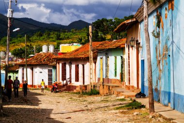 TRINIDAD, CUBA - 21 Kasım 2017: Renkli (kırmızı, sarı, yeşil, mavi) Trinidad caddesi manzaralı evler, kaldırımlı yollar ve pencerelerde parmaklıklar. Trinidad, UNESCO tarafından listelenmiş ve popüler bir şehir..