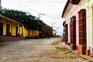 TRINIDAD, CUBA - 21 Kasım 2017: Renkli (kırmızı, sarı, yeşil, mavi) Trinidad caddesi manzaralı evler, kaldırımlı yollar ve pencerelerde parmaklıklar. Trinidad, UNESCO tarafından listelenmiş ve popüler bir şehir..
