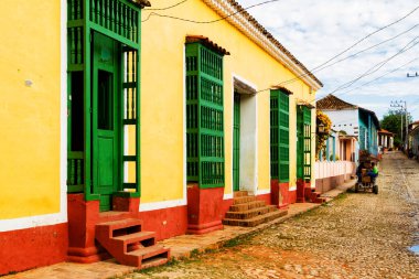 TRINIDAD, CUBA - 21 Kasım 2017: Renkli (kırmızı, sarı, yeşil, mavi) Trinidad caddesi manzaralı evler, kaldırımlı yollar ve pencerelerde parmaklıklar. Trinidad, UNESCO tarafından listelenmiş ve popüler bir şehir..