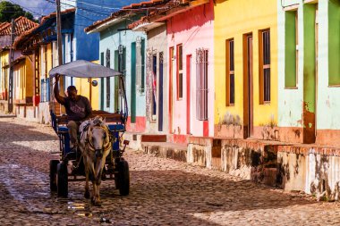 TRINIDAD, CUBA - 21 Kasım 2017: Renkli (kırmızı, sarı, yeşil, mavi) Trinidad caddesi manzaralı evler, kaldırımlı yollar ve pencerelerde parmaklıklar. Trinidad, UNESCO tarafından listelenmiş ve popüler bir şehir..