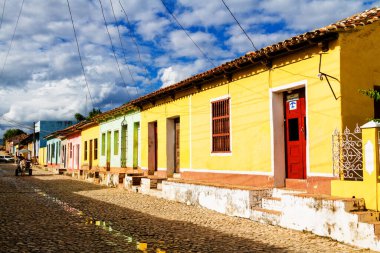 TRINIDAD, CUBA - 21 Kasım 2017: Renkli (kırmızı, sarı, yeşil, mavi) Trinidad caddesi manzaralı evler, kaldırımlı yollar ve pencerelerde parmaklıklar. Trinidad, UNESCO tarafından listelenmiş ve popüler bir şehir..