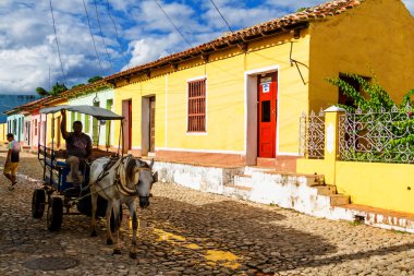 TRINIDAD, CUBA - 21 Kasım 2017: Renkli (kırmızı, sarı, yeşil, mavi) Trinidad caddesi manzaralı evler, kaldırımlı yollar ve pencerelerde parmaklıklar. Trinidad, UNESCO tarafından listelenmiş ve popüler bir şehir..