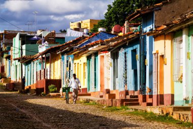 TRINIDAD, CUBA - 21 Kasım 2017: Renkli (kırmızı, sarı, yeşil, mavi) Trinidad caddesi manzaralı evler, kaldırımlı yollar ve pencerelerde parmaklıklar. Trinidad, UNESCO tarafından listelenmiş ve popüler bir şehir..