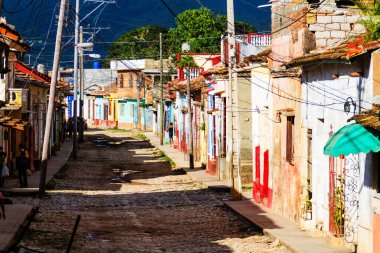 TRINIDAD, CUBA - 21 Kasım 2017: Renkli (kırmızı, sarı, yeşil, mavi) Trinidad caddesi manzaralı evler, kaldırımlı yollar ve pencerelerde parmaklıklar. Trinidad, UNESCO tarafından listelenmiş ve popüler bir şehir..