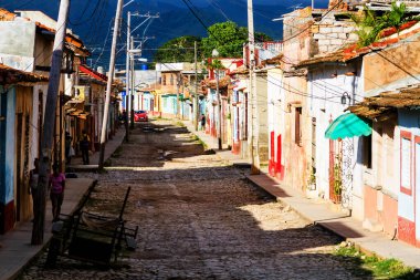 TRINIDAD, CUBA - 21 Kasım 2017: Renkli (kırmızı, sarı, yeşil, mavi) Trinidad caddesi manzaralı evler, kaldırımlı yollar ve pencerelerde parmaklıklar. Trinidad, UNESCO tarafından listelenmiş ve popüler bir şehir..