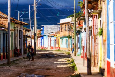 TRINIDAD, CUBA - 21 Kasım 2017: Renkli (kırmızı, sarı, yeşil, mavi) Trinidad caddesi manzaralı evler, kaldırımlı yollar ve pencerelerde parmaklıklar. Trinidad, UNESCO tarafından listelenmiş ve popüler bir şehir..
