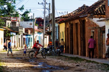 TRINIDAD, CUBA - 21 Kasım 2017: Renkli (kırmızı, sarı, yeşil, mavi) Trinidad caddesi manzaralı evler, kaldırımlı yollar ve pencerelerde parmaklıklar. Trinidad, UNESCO tarafından listelenmiş ve popüler bir şehir..