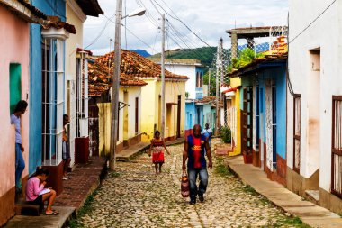 TRINIDAD, CUBA - 21 Kasım 2017: Renkli (kırmızı, sarı, yeşil, mavi) Trinidad caddesi manzaralı evler, kaldırımlı yollar ve pencerelerde parmaklıklar. Trinidad, UNESCO tarafından listelenmiş ve popüler bir şehir..
