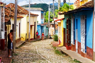 TRINIDAD, CUBA - 21 Kasım 2017: Renkli (kırmızı, sarı, yeşil, mavi) Trinidad caddesi manzaralı evler, kaldırımlı yollar ve pencerelerde parmaklıklar. Trinidad, UNESCO tarafından listelenmiş ve popüler bir şehir..