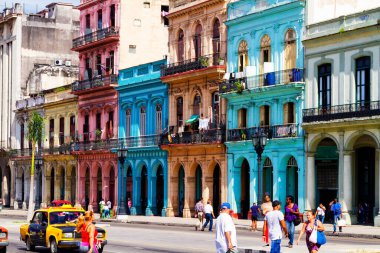 HAVANA, CUBA - 14 Kasım 2017: İnsanlar, eski arabalar ve renkli binaların olduğu tipik sokak sahnesi. 2 milyondan fazla nüfusuyla Havana, Küba 'nın başkenti ve Karayipler' in en büyük şehridir.