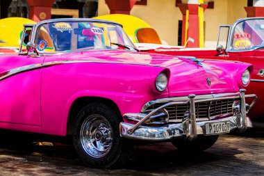 HAVANA, CUBA - 18 Kasım 2017: Havana, Küba sokaklarında eski renkli klasik araba. Ambargo nedeniyle Amerikan arabaları hala kullanılıyor ve turistler için taksi veya taşımacılık görevi görüyor.