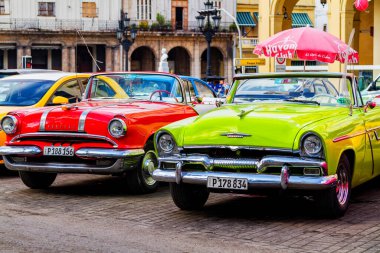 HAVANA, CUBA - 18 Kasım 2017: Havana, Küba sokaklarında eski renkli klasik araba. Ambargo nedeniyle Amerikan arabaları hala kullanılıyor ve turistler için taksi veya taşımacılık görevi görüyor.