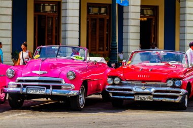 HAVANA, CUBA - 18 Kasım 2017: Havana, Küba sokaklarında eski renkli klasik araba. Ambargo nedeniyle Amerikan arabaları hala kullanılıyor ve turistler için taksi veya taşımacılık görevi görüyor.