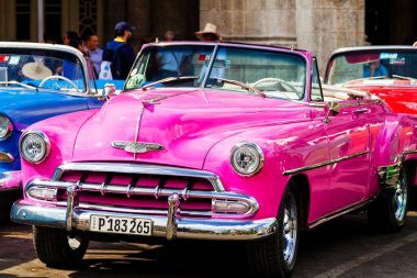 HAVANA, CUBA - 18 Kasım 2017: Havana, Küba sokaklarında eski renkli klasik araba. Ambargo nedeniyle Amerikan arabaları hala kullanılıyor ve turistler için taksi veya taşımacılık görevi görüyor.