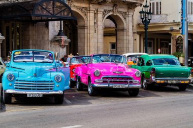 HAVANA, CUBA - 18 Kasım 2017: Havana, Küba sokaklarında eski renkli klasik araba. Ambargo nedeniyle Amerikan arabaları hala kullanılıyor ve turistler için taksi veya taşımacılık görevi görüyor.