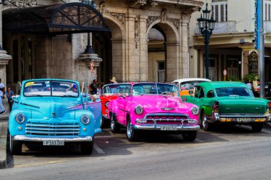 HAVANA, CUBA - 18 Kasım 2017: Havana, Küba sokaklarında eski renkli klasik araba. Ambargo nedeniyle Amerikan arabaları hala kullanılıyor ve turistler için taksi veya taşımacılık görevi görüyor.