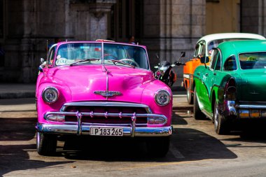 HAVANA, CUBA - 18 Kasım 2017: Havana, Küba sokaklarında eski renkli klasik araba. Ambargo nedeniyle Amerikan arabaları hala kullanılıyor ve turistler için taksi veya taşımacılık görevi görüyor.