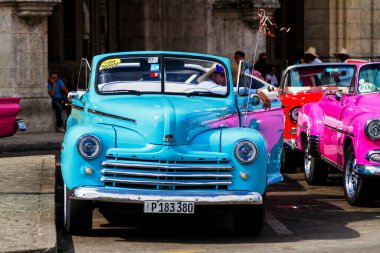 HAVANA, CUBA - 18 Kasım 2017: Havana, Küba sokaklarında eski renkli klasik araba. Ambargo nedeniyle Amerikan arabaları hala kullanılıyor ve turistler için taksi veya taşımacılık görevi görüyor.