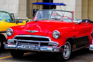 HAVANA, CUBA - 18 Kasım 2017: Havana, Küba sokaklarında eski renkli klasik araba. Ambargo nedeniyle Amerikan arabaları hala kullanılıyor ve turistler için taksi veya taşımacılık görevi görüyor.